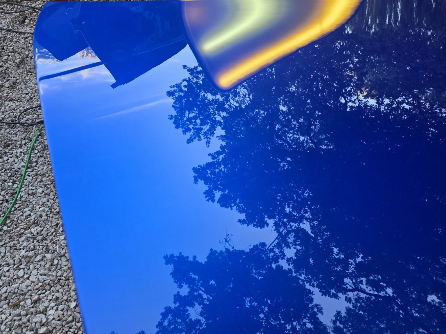 Capot Porsche Boxster bleu nacré après débosselage : reflets parfaitement uniformes sous la lampe