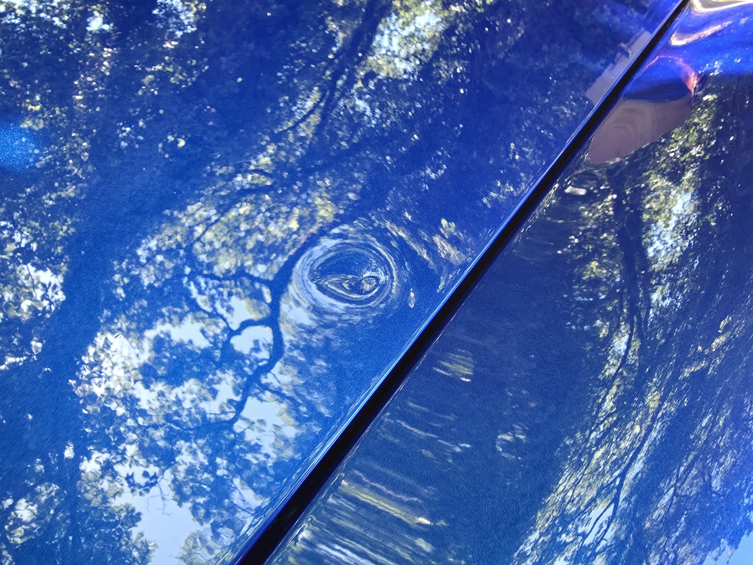 Gros plan du point d'impact piqué sur le capot aluminium repeint